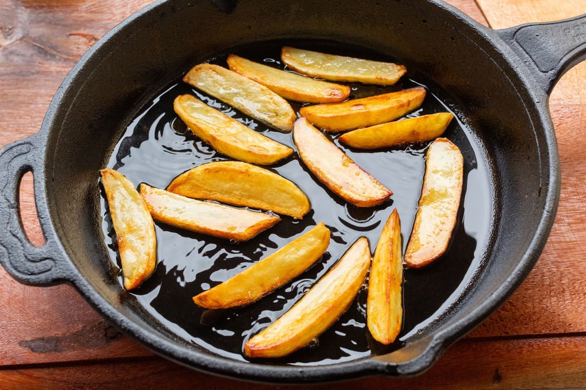 A cast iron skillet being rubbed with oil to season it