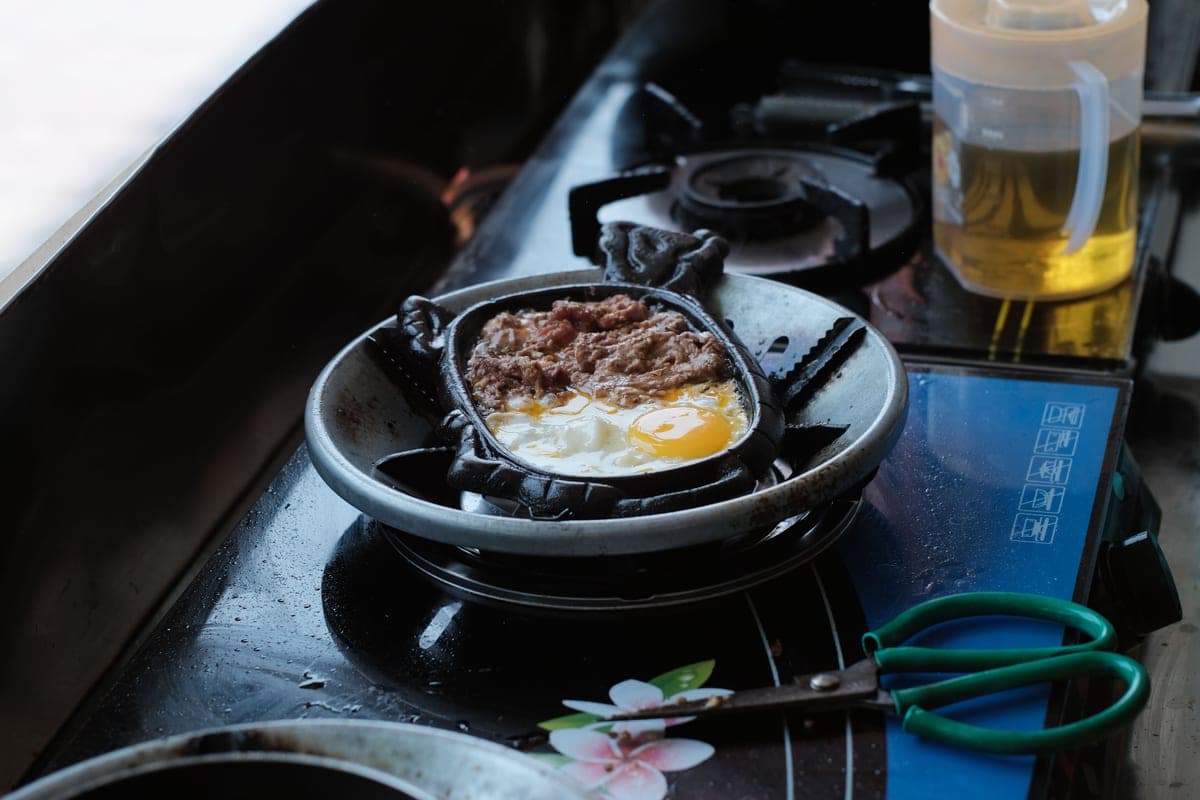 A seasoned cast iron skillet heating on a stovetop burner